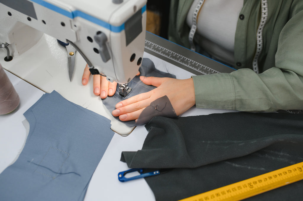 Seamstress hand-sewing GOTS-certified organic cotton fabric in a Fair Trade Certified facility